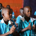Children singing in the classroom of a primary school, Uganda