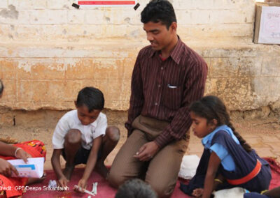 Children with teacher learning to count in rural school, Chhattisgarh, India