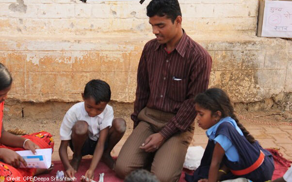 Children with teacher learning to count in rural school, Chhattisgarh, India