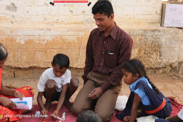 Children with teacher learning to count in rural school, Chhattisgarh, India