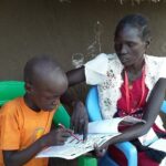 South Sudanese volunteers assess a child's reading