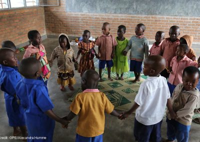 Children singing and dancing in a ring n their pre-school classroom at Jean de la Mennais School in Burera district, rural Rwanda.