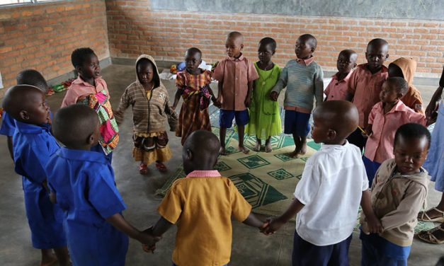 Children singing and dancing in a ring n their pre-school classroom at Jean de la Mennais School in Burera district, rural Rwanda.