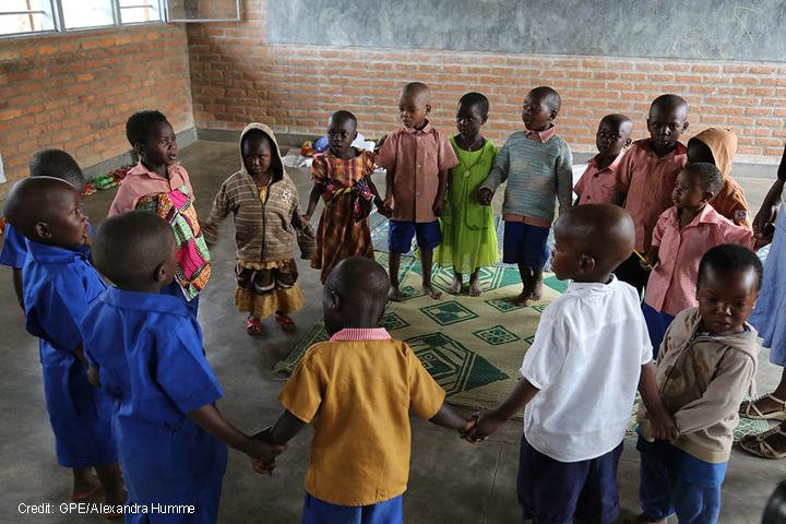 Children singing and dancing in a ring n their pre-school classroom at Jean de la Mennais School in Burera district, rural Rwanda.