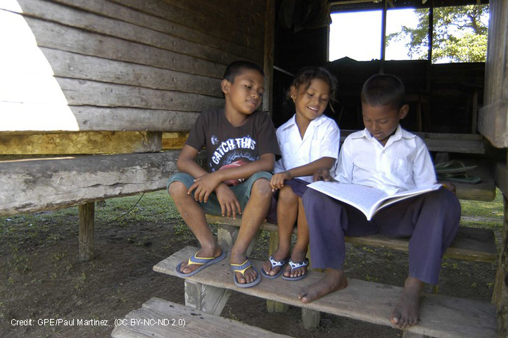Two boys and a girl reading on a step, Honduras