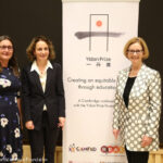 Pauline Rose from the REAL Centre, Lucy Lake from CAMFED and the Honourable Julia Gillard stand in front of a conference banner for the Yidan Prize Foundation conference organised by the REAL Centre and CAMFED on 7 October 2021.
