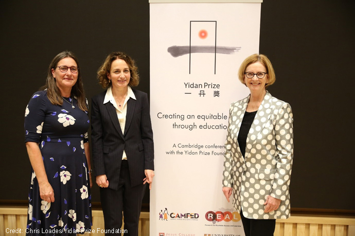 Pauline Rose from the REAL Centre, Lucy Lake from CAMFED and the Honourable Julia Gillard stand in front of a conference banner for the Yidan Prize Foundation conference organised by the REAL Centre and CAMFED on 7 October 2021.