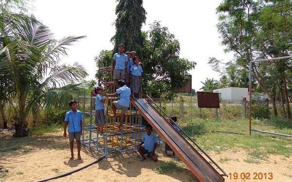 A group of primary students play in the school playground on slide and climbing frame, Eureka Program, Tamil Nadu,