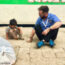 Joel David Bond plays with local refugee children, Iraq Man sitting on ground with a small child