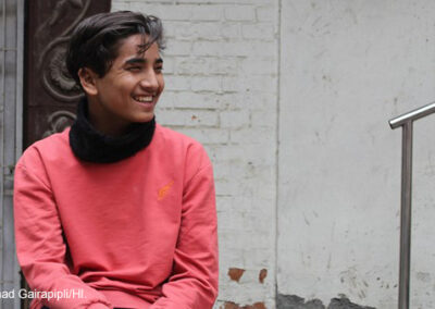 Boy smiling, wearing an orange shirt