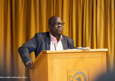 Professor Eugene Ndabaga from the University of Rwanda – College of Education standing at a podium giving a presentation at the Cambridge Africa Day conference on 6 July 2022.