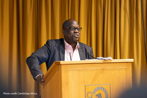 Professor Eugene Ndabaga from the University of Rwanda – College of Education standing at a podium giving a presentation at the Cambridge Africa Day conference on 6 July 2022.