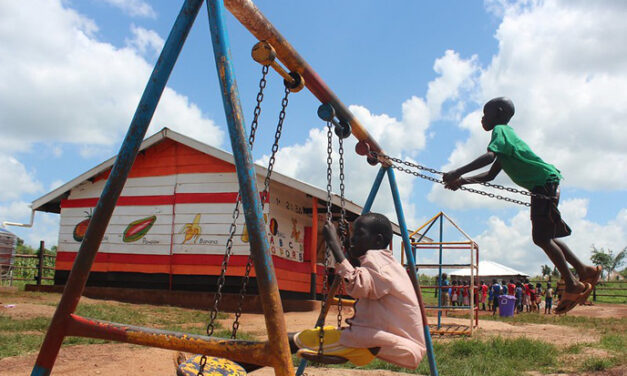 Children playing on the swings in the playgrounds of their pre-school, Uganda.