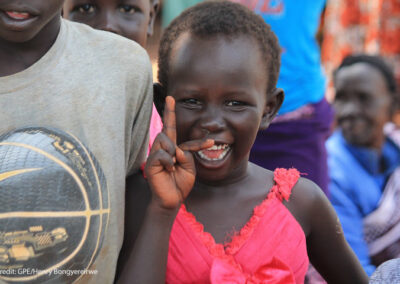Young girl smiling at Kiryandongo refugee settlement, Uganda.