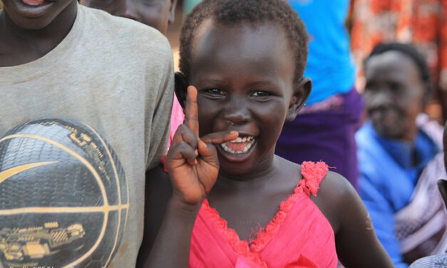 Young girl smiling at Kiryandongo refugee settlement, Uganda.
