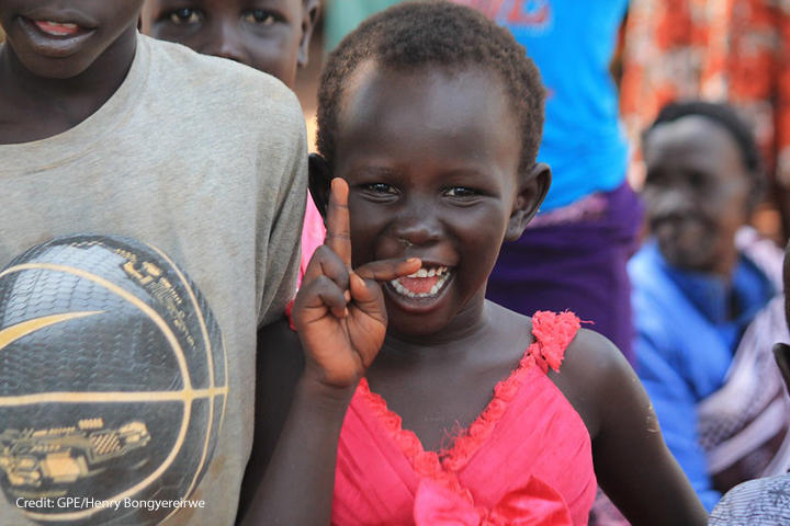 Young girl smiling at Kiryandongo refugee settlement, Uganda.