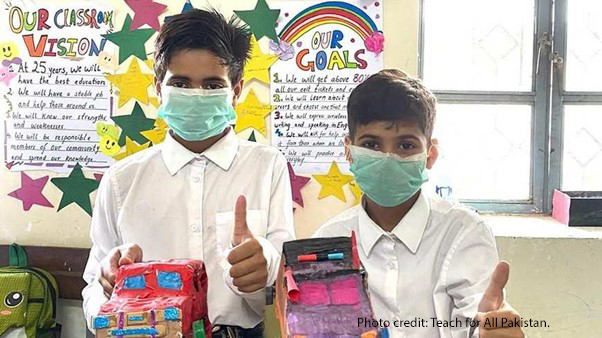 Teach For Pakistan student Abdullah (left) and a classmate with two of their recycled cars.