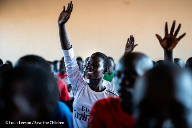 Harriet, a 14-year-old girl, sticking her hand up at school, Bidi Bidi Refugee settlement, Northern Uganda.