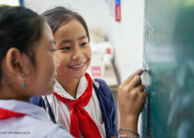 Two fourth grade girl students look at the blackboard together, Somsanouk Primary School, Pak Ou District, Lao PDR.