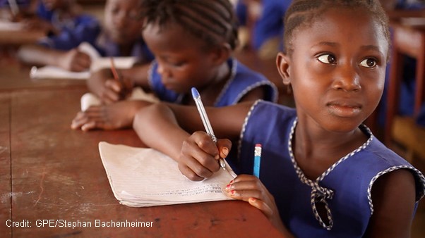 Girls wearing blue uniform writing at desks