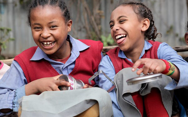 Two girls laughing on their lunchbreak at Hidassie School, Addis Ababa, Ethiopia.