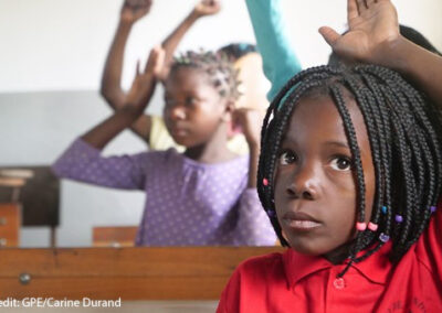 Girl puts up her hand in a newly-built classroom in Mozambique after schools were partially or full destroyed by Cyclone Idai in 2019.