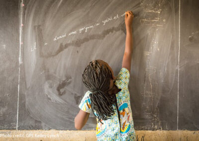 Student reaches up to write in French on the blackboard in Class 3 at the Sandogo ‘B’ Primary School, District 7, Ouagadougou, Burkina Faso.