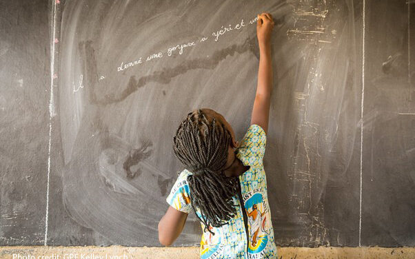 Student reaches up to write in French on the blackboard in Class 3 at the Sandogo ‘B’ Primary School, District 7, Ouagadougou, Burkina Faso.
