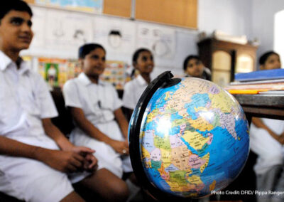 Children sit in a classroom in Chennai in front of a world globe, learning about children on the other side of the world through a schools partnership scheme, India.