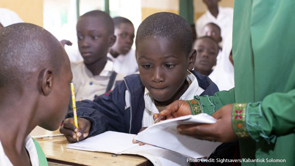 Abdullahi, a boy with partial visual impairment, receives extra support at school in Nigeria, through the Sightsavers SMILE project.