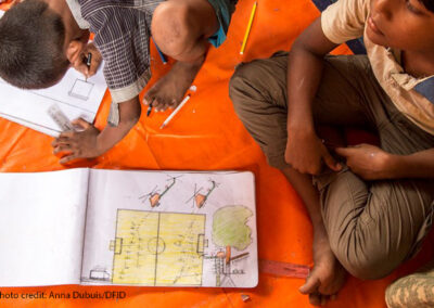 Rohingya children sitting on the floor drawing pictures of what they witnessed in Myanmar. They are at a UNICEF child friendly space at Batukhali refugee camp in Bangladesh, where art therapy and counselling help Rohingya children recover from the trauma they have experienced.