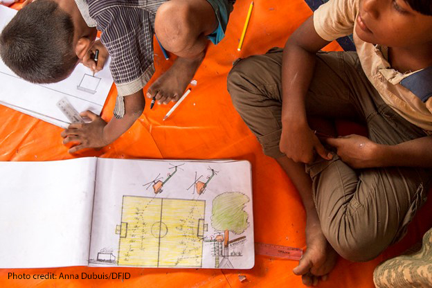 Rohingya children sitting on the floor drawing pictures of what they witnessed in Myanmar. They are at a UNICEF child friendly space at Batukhali refugee camp in Bangladesh, where art therapy and counselling help Rohingya children recover from the trauma they have experienced.