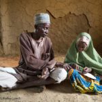 Grandfather and village chief Mai Unguwa Ali Abdullahi sits with his granddaughter Mariam Isah, 8, in Nigeria. The village chief wants his granddaughter to become a doctor or nurse to help her community but Mariam wants to become a teacher to help other children learn.