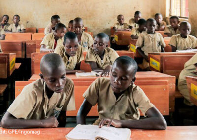 Alt text: Boys share books in class in Burundi