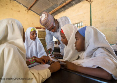 Four girls in class with their teacher Tukur Yusuf at Miga Central Primary School, (a secular ‘Western’ school), Jigawa State, Nigeria