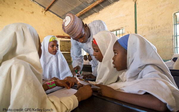 Four girls in class with their teacher Tukur Yusuf at Miga Central Primary School, (a secular ‘Western’ school), Jigawa State, Nigeria