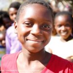 Twelve-year-old Suria smiles directly at the camera. The Adolescent Girls Empowerment Program – led by the Population Council – is currently helping more than 10,000 girls like Suria benefit from safe spaces in Zambia.