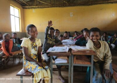 Children laugh and smile to the front of the classroom during a lesson.