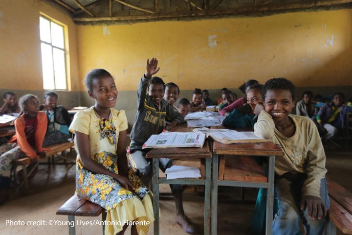 Children laugh and smile to the front of the classroom during a lesson.