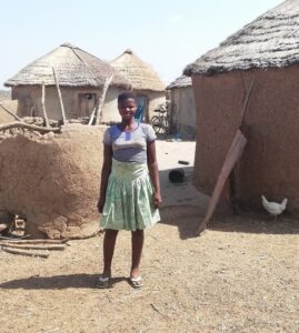 Girl standing in front of a  rustic building