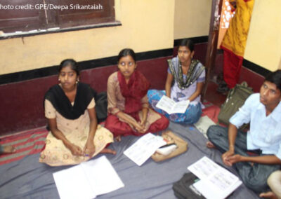 Students sit cross-legged on the floor in a class discussion, Bankura West Bengal, India.