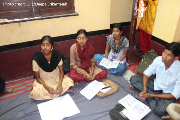 Students sit cross-legged on the floor in a class discussion, Bankura West Bengal, India.