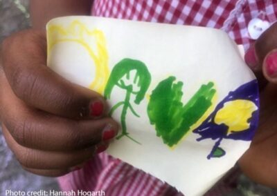 Me, my green heart, the daffodil and the crocus. A drawing by a child in a UK urban park. A child's hand holding a drawing in green , yellow and blue felt tip pen.