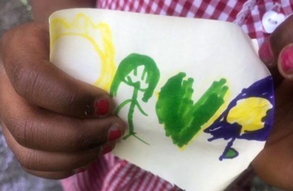 Me, my green heart, the daffodil and the crocus. A drawing by a child in a UK urban park. A child's hand holding a drawing in green , yellow and blue felt tip pen.