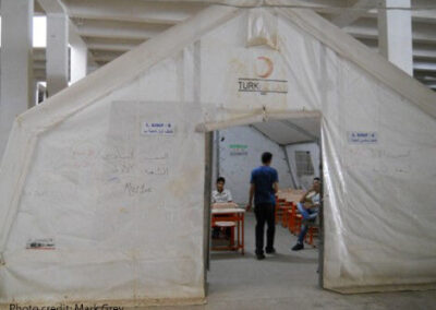 Volunteer Syrian teachers confer in a classroom tent erected in an abandoned warehouse at the Islahiye refugee camp in Turkey.