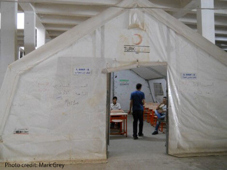 Volunteer Syrian teachers confer in a classroom tent erected in an abandoned warehouse at the Islahiye refugee camp in Turkey.