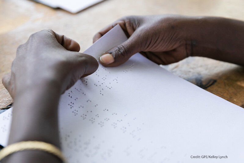 Hands reading a braille page. A blind student at Sebeta School for the Blind checks her answers after taking a geography exam; Sebeta, Oromia, Ethiopia.