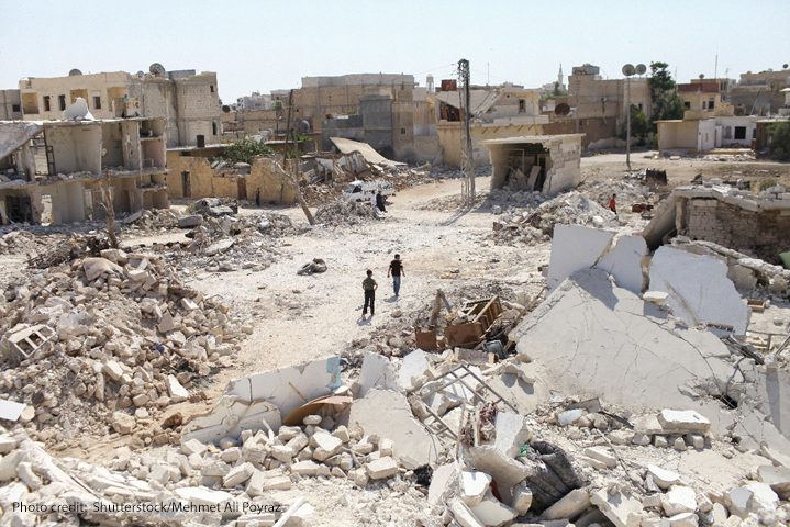 Children in rubble of demolished buildings due to conflict in Syria