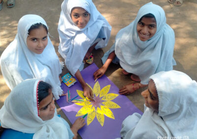 a group of girls sit around and create a flower with each petal being a key positive character attribute, such as: loving, bold, lovely good friend, strong, bold, etc.