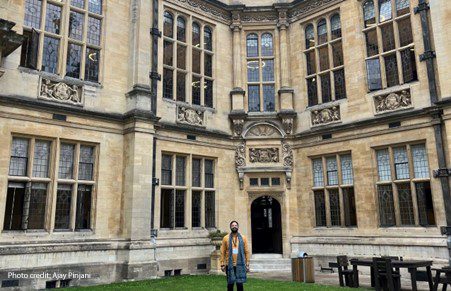 Ajay Pinjani, a 2023 UKFIET conference participant, stands in the quad at the Oxford Exam Schools.